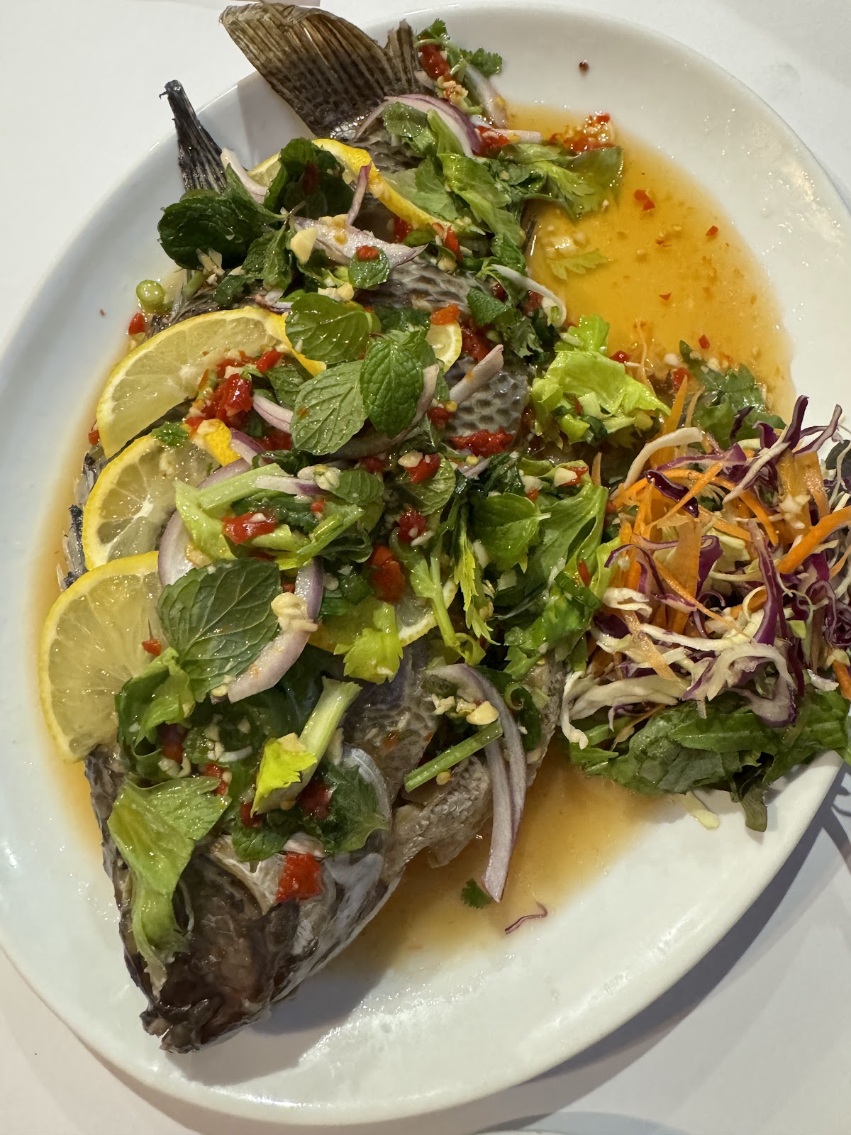 Whole steamed fish under a Thai salad dressing of herbs, chilli and lemon